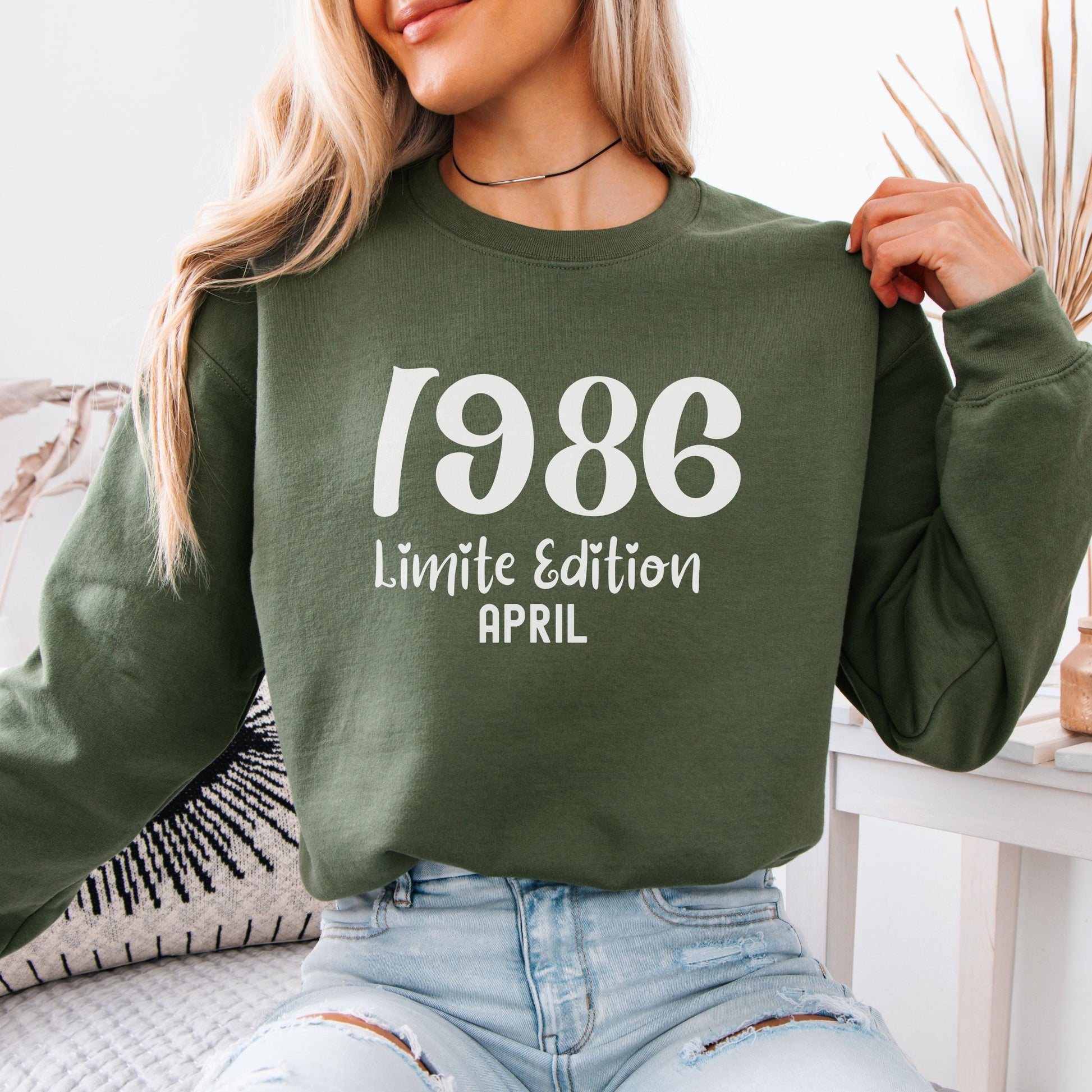 Folded green retro style sweatshirt with bold white 1986 print and special edition March text, vintage inspired birthday design for 40th milestone celebration.