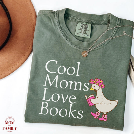folded comfort colors® shirt with white lettering saying "Cool Moms Love Books", perfect gift for readers, book lovers, or teachers