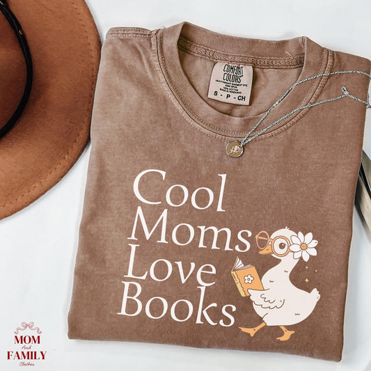 folded comfort colors® shirt with white lettering saying "Cool Moms Love Books", perfect gift for readers, book lovers, or teachers