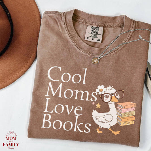 folded comfort colors® shirt with white lettering saying "Cool Moms Love Books", perfect gift for readers, book lovers, or teachers